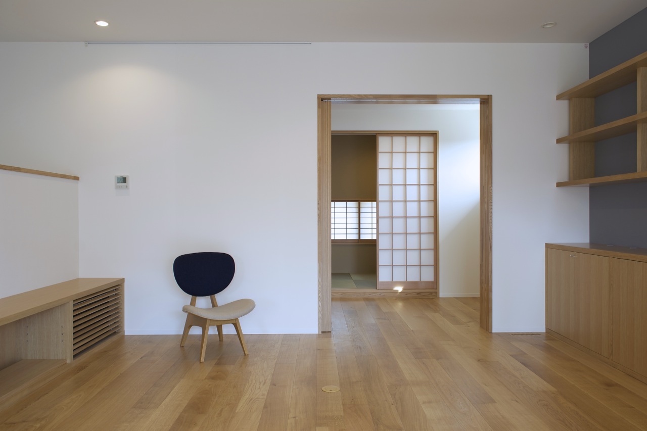 Living area with TV shoves on the left, bookshelves on the right and piano room and the Japanese room sliding doors opened.   Living area with TV shoves on the left, bookshelves on the right and piano room and the Japanese room sliding doors opened.